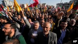 Iranian protestors chant slogans as they wave their national flags and Lebanon's militant Hezbollah group and Palestinian flags in an anti-Israel rally at Enqelab-e-Eslami (Islamic Revolution) Square in Tehran, Iran, Oct. 18, 2023.