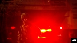 A member of California National Guard watches for activity on a street May 31, 2020, in Los Angeles.