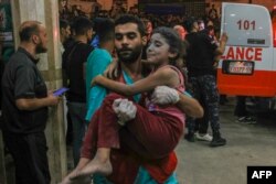 A Palestinian child injured in an Israeli airstrike is carried inside the Nasser hospital in Khan Yunis in the southern area of the Gaza Strip on Oct. 17, 2023.