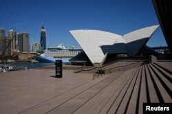 FILE - The mostly deserted steps of the Sydney Opera House, where scheduled public performances have been canceled due to the coronavirus disease (COVID-19), are seen on a quiet morning in Sydney, March 18, 2020.