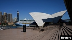 FILE - The mostly deserted steps of the Sydney Opera House, where scheduled public performances have been canceled due to the coronavirus disease (COVID-19), are seen on a quiet morning in Sydney, Australia, March 18, 2020.