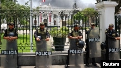 Agentes de policía hacen guardia en el Congreso Nacional mientras miembros de sindicatos y organizaciones sociales protestan en el marco de la cumbre de Cooperación Económica Asia-Pacífico (APEC), en Lima, Perú, el 13 de noviembre de 2024.