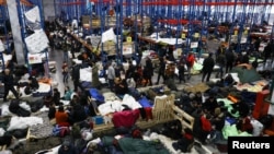 Migrants gather at a transport and logistics center near the Belarusian-Polish border in the Grodno region, Belarus, Belarus, Nov. 19, 2021. 