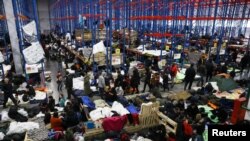 বেলারুশের গ্রোডনো অঞ্চলে পোল্যান্ড-বেলারুশ সীমান্তের কাছে একটি পরিবহন ও সরবরাহ কেন্দ্রে অভিবাসীরা জড়ো হচ্ছে।১৯ নভেম্বর ২০২১। (ছবি-রয়টার্স/ক্যাস্পার পেম্পেল) 