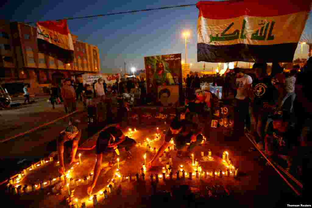 이라크 나자프에서 시민들이 반정부 시위 1주년을 기념하기 위해 거리에 촛불을 밝히고 있다. 이라크 시민들은 지난해 높은 실업률과 정치인들의 부정부패에 항의 시위를 벌이며 정부 진압 경찰과 충돌해 250여명이 사망하고 8천 여명이 부상당했다. 