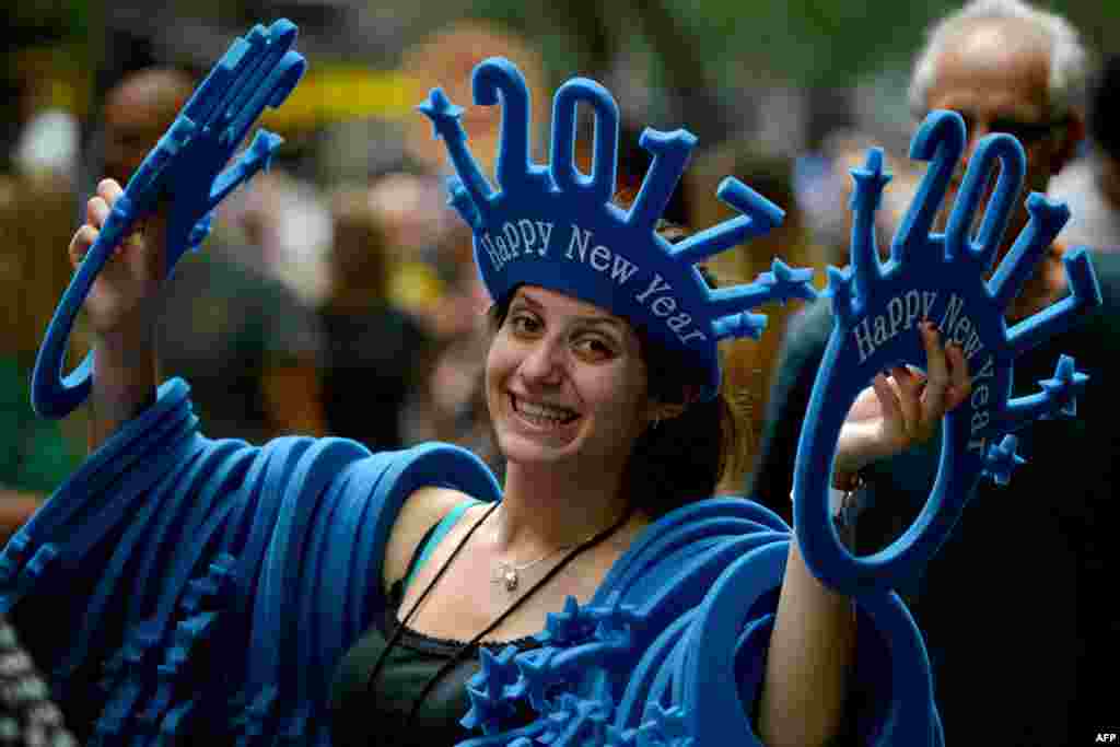 A woman sells &quot;Happy New Year 2017&quot; headwear on a shopping street in Sydney, Australia.
