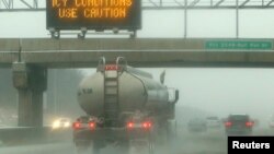 Las malas condiciones del tiempo provocan accidentes en las carreteras. En esta foto un camión arroja hielo al transitar por la autopista congelada en el área de Manassas en Virginia. 