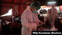 Petugas kesehatan bersiap membantu pasien COVID-19 di tenda sementara di luar ruang gawat darurat rumah sakit pemerintah di Bekasi, 25 Juni 2021. (Foto: REUTERS/Willy Kurniawan)