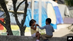 FILE - In this Nov. 18, 2020, photo, children play at a camp of asylum seekers stuck at America's doorstep, in Matamoros, Mexico. 