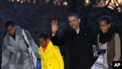 President Barack Obama, first lady Michelle Obama and their daughters Sasha and Malia arrive on the South Lawn of the White House, Tuesday, Jan. 3, 2012, in Washington.