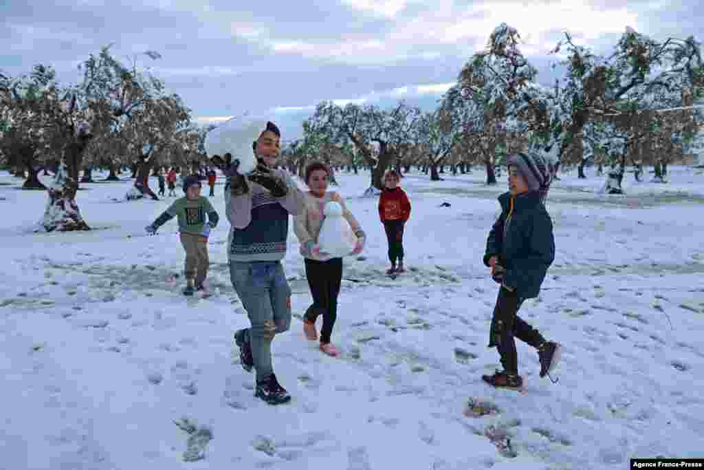 Children play in the snow at a camp for internally displaced Syrians near Afrin city in the rebel-controlled northern countryside of Syria&#39;s Aleppo province.