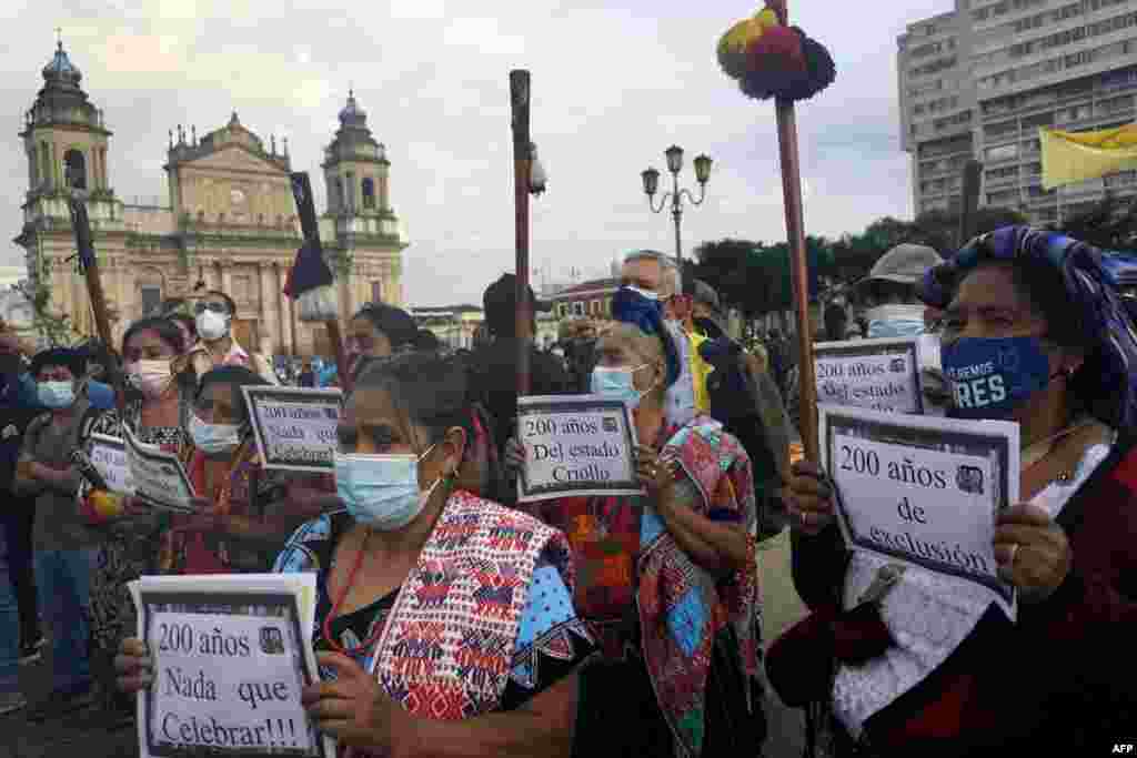 Los indígenas mayas sostienen carteles durante una protesta contra el Bicentenario de la Independencia de Guatemala.