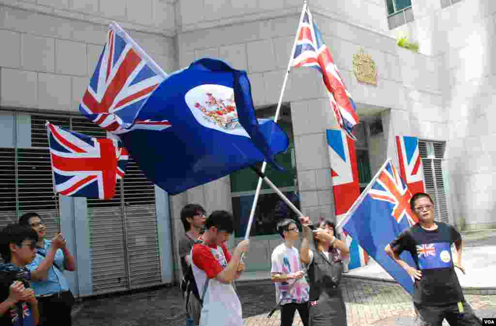 香港人優先約十名成員在英國駐港總領事館大門前，揮舞英國國旗及港英時代的香港旗 (美國之音湯惠芸)