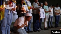 ARCHIVO - La madre de un venezolano detenido durante las protestas contra los resultados de las elecciones presidenciales reza durante una vigilia con velas en la Universidad Central de Venezuela en Caracas, Venezuela, el 17 de diciembre de 2024. REUTERS/Gaby Oraa