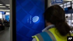 Un técnico de servicios de campo de TI trabaja en el software en una pantalla de información cerca de las puertas de United Airlines en el Aeropuerto Internacional O'Hare de Chicago, el viernes 19 de julio de 2024.