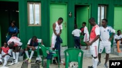 FILE - Members of a local football team change shortly before a training session at the Clara Town Survivors Sports Park in Monrovia, on October 6, 2023.