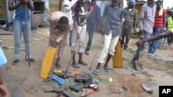 Warga berkumpul di sebuah lokasi ledakan di Maiduguri, Nigeria, Senin (21/9).