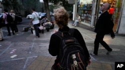 FILE - An Iranian woman without a mandatory headscarf, or hijab, walks in downtown Tehran, Iran, June 10, 2024.