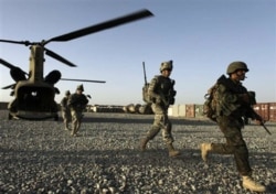 FILE - U.S. infantrymen and Afghan Army commandos exit a U.S. Army helicopter in Afghanistan's southern Kandahar province, Sept. 11, 2010.