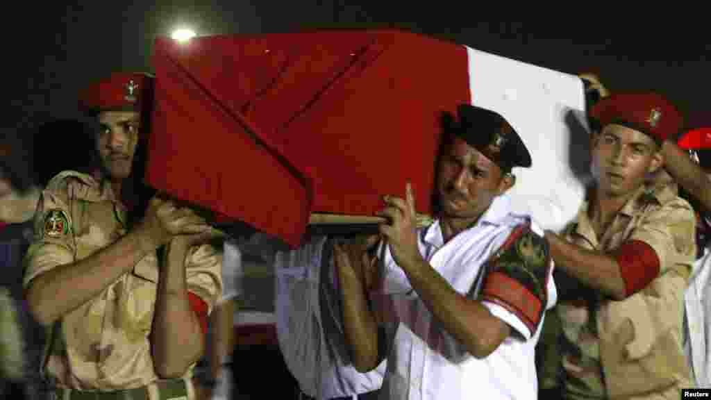 The caskets of 25 policemen killed Monday morning near the Sinai town of Rafah lay on the ground after arriving in Cairo August 19, 2013.