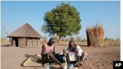 Feb. 8, 2010. Senwei Village, Terekeka Region, South Sudan. Guinea worm Eradication Program Village Volunteer Puru tends to her husband, Garbino's Guinea worm leg wound, at their home.