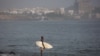 A surfer surveys the waves off Dakar, Senegal. (Annika Hammerschlag/VOA)