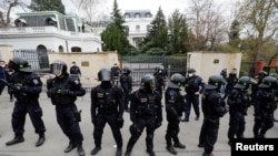 Police officers stand outside the Russian Embassy during a protest over Russian intelligence services' alleged involvement in an ammunition depot explosion in the Vrbetice area in 2014, in Prague, Czech Republic, April 18, 2021.