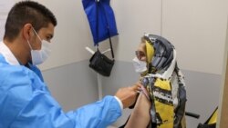 An Iranian woman receives a dose of a coronavirus vaccine at a center in Tehran, August 9, 2021. (Majid Asgaripour/Reuters)