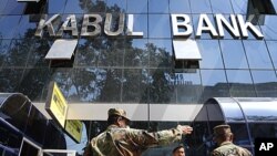 Afghan soldiers chat in front of the main office of Kabul Bank in Kabul, Afghanistan, Sept. 1, 2010.