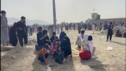 People gathered outside the airport react to gunfire, in Kabul, Afghanistan Aug. 18, 2021 in this still image taken from video. (ASVAKA NEWS)