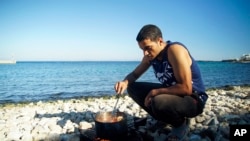 Un migrant cuisinant sur une plage de l'ile de Chios, en Grèce, le 29 septembre 2016.