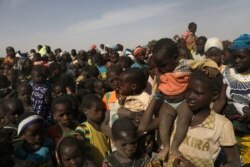 FILE - Displaced children wait for help at a village of Dablo area, Burkina Faso, March 2, 2019.