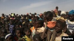 FILE - Displaced children wait for help at a village of Dablo area, Burkina Faso, March 2, 2019. 