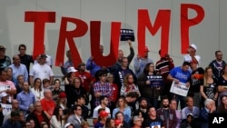 FILE - Supporters hold signs for Republican presidential candidate Donald Trump at a campaign rally in Grand Rapids, Michigan, Nov. 8, 2016. Having lost the election to Trump, Democrats in Midwesterns U.S. states now face a tough battle to reclaim supporters who switched party lines.