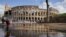 Niños juegan en un charco, junto al Coliseo en Roma, un día después de que fuertes cientos y aguaceros azotaran la capital italiana.