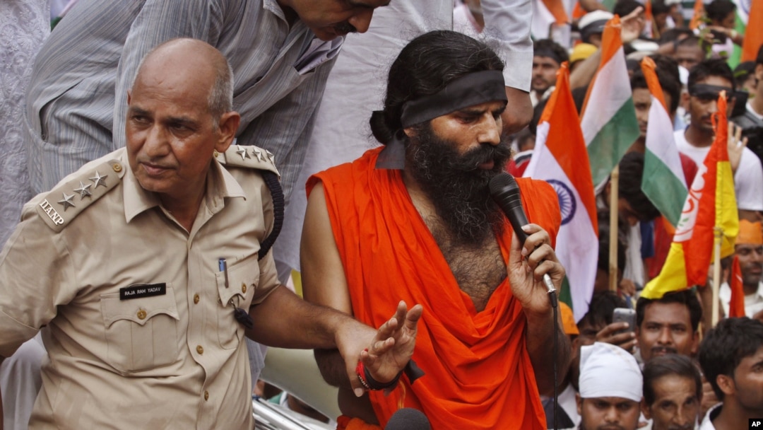 An Indian senior policeman detains yoga guru Baba Ramdev, right, during an anti-corruption protest in New Delhi, India, August 13, 2012. 