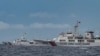 Kapal Penjaga Pantai China (kanan) terlihat melewati kapal Penjaga Pantai Filipina BRP Cape Engaño (kiri), seperti yang difoto dari BRP Cabra selama misi pasokan ke Sabina Shoal di perairan yang disengketakan di Laut Cina Selatan, 26 Agustus 2024. (Jam Sta Rosa / AFP)