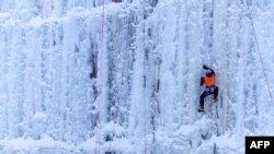 Seorang peserta tengah mendaki pilar es dalam Festival Panjat Es di Robinson Ice Park, Sandstone, Minnesota, 7 Januari 2022. (Kerem Yucel/AFP/ilustrasi)