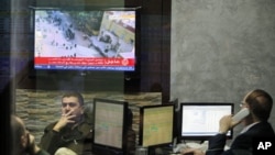 Investors watch the situation in Egypt on a television screen at the Amman Stock Exchange in Jordan, January 31, 2011