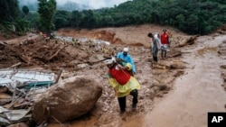 FILE - Rescuers make their way to the upper regions as they search through mud and debris for a third day after landslides set off by torrential rains in Wayanad district, Kerala state, India, Aug. 1, 2024.