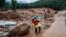 FILE - Rescuers make their way to the upper regions as they search through mud and debris for a third day after landslides set off by torrential rains in Wayanad district, Kerala state, India, Aug. 1, 2024.
