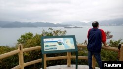 Ayah dari salah satu dari 12 aktivis pro-demokrasi Hong Kong yang ditahan, memperhatikan pemandangan distrik Yantian di Kota Shenzen, China, di Hong Kong, 21 November 2020. (Foto: Reuters)