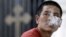 A man blows out cigarette smoke outside a church in Beijing, (File 2010)