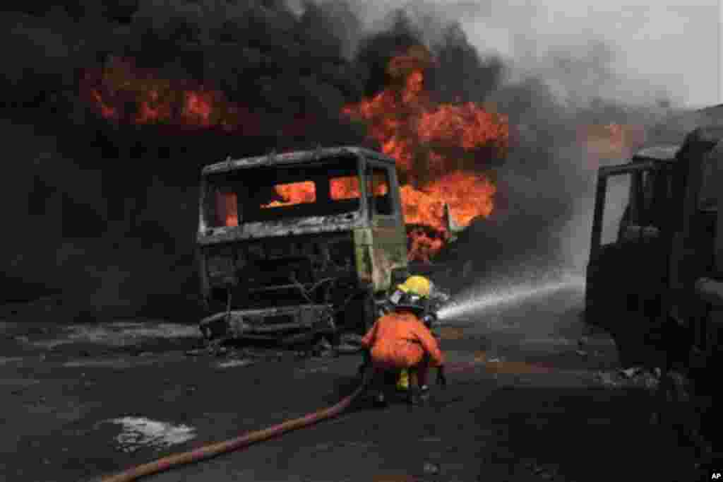 Firefighters try to contain a fire at an informal diesel fuel depot in Lagos, Nigeria on Thursday, Feb. 16, 2012.