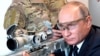 RUSSIA -- Russian President Vladimir Putin aims a sniper rifle during a visit to the Patriot military exhibition center outside Moscow, September 19, 2018