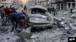 Un hombre inspecciona un vehículo destruido durante un ataque en la calle Jalaa de Gaza, el 14 de enero de 2025.