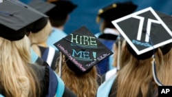 FILE - Graduates, including one looking for a job, are seated during George Washington University's commencement exercises on the National Mall in Washington, May 17, 2015.