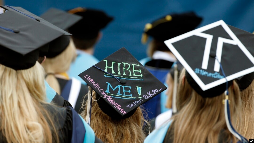 FILE - Graduates, including one looking for a job, are seated during George Washington University's commencement exercises on the National Mall in Washington, May 17, 2015.
