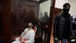 Mukhammadsobir Faizov, salah satu terdakwa dalam serangan teror di gedung konser Crocus, duduk di kurungan kaca saaat hadir di Pengadilan Distrik Basmanny di Moskow, Rusia, pada 24 Maret 2024. (Foto: AP/Alexander Zemlianichenko)