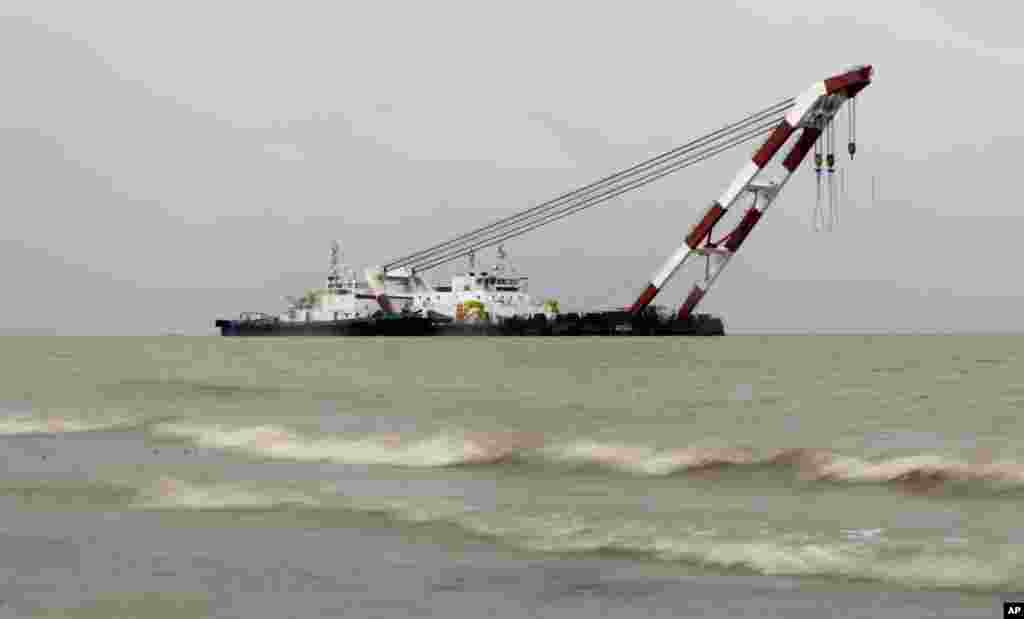 A heavy lift offshore crane arrives for rescue work at the site of a ferry capsize in the River Padma in Munshiganj district, Bangladesh, Tuesday, Aug. 5, 2014.